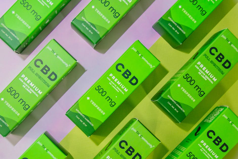 Opakowania oleju CBD o stężeniu 500 mg, w zielonych kartonach z napisami "CBD" i "Premium". Produkty są rozmieszczone na pastelowym tle, co podkreśla ich świeżość i naturalność.